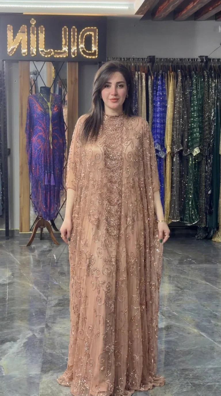 Front view of model wearing champagne hand-beaded cape maxi gown