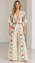 Front view of model wearing cream floral tie-front crop top and wide-leg pants set