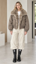 Model wearing taupe faux fur collar bomber jacket front view with cream cargo pants