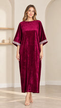 Full front view of model wearing burgundy crushed velvet kaftan maxi dress with embroidered cuffs