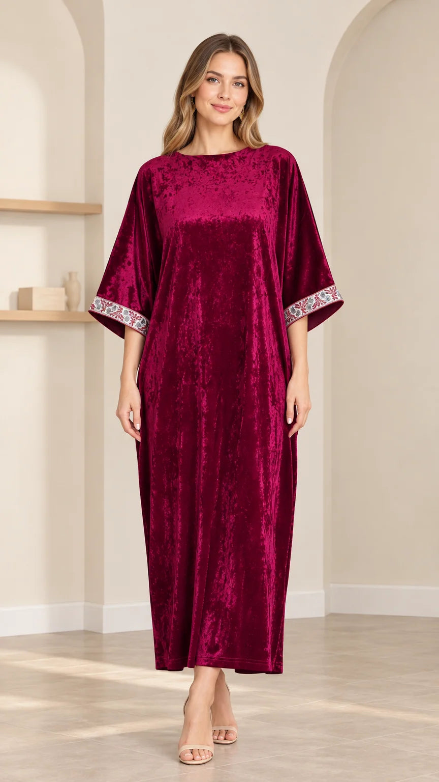 Full front view of model wearing burgundy crushed velvet kaftan maxi dress with embroidered cuffs