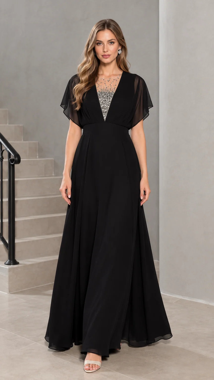 Front view of model wearing black flutter sleeve chiffon evening maxi dress with rhinestone illusion neckline