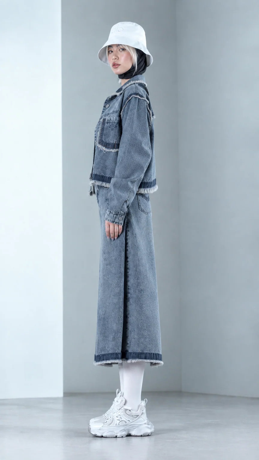 Side profile view of Denim Blue two-piece denim co-ord set with raw fringe hems
