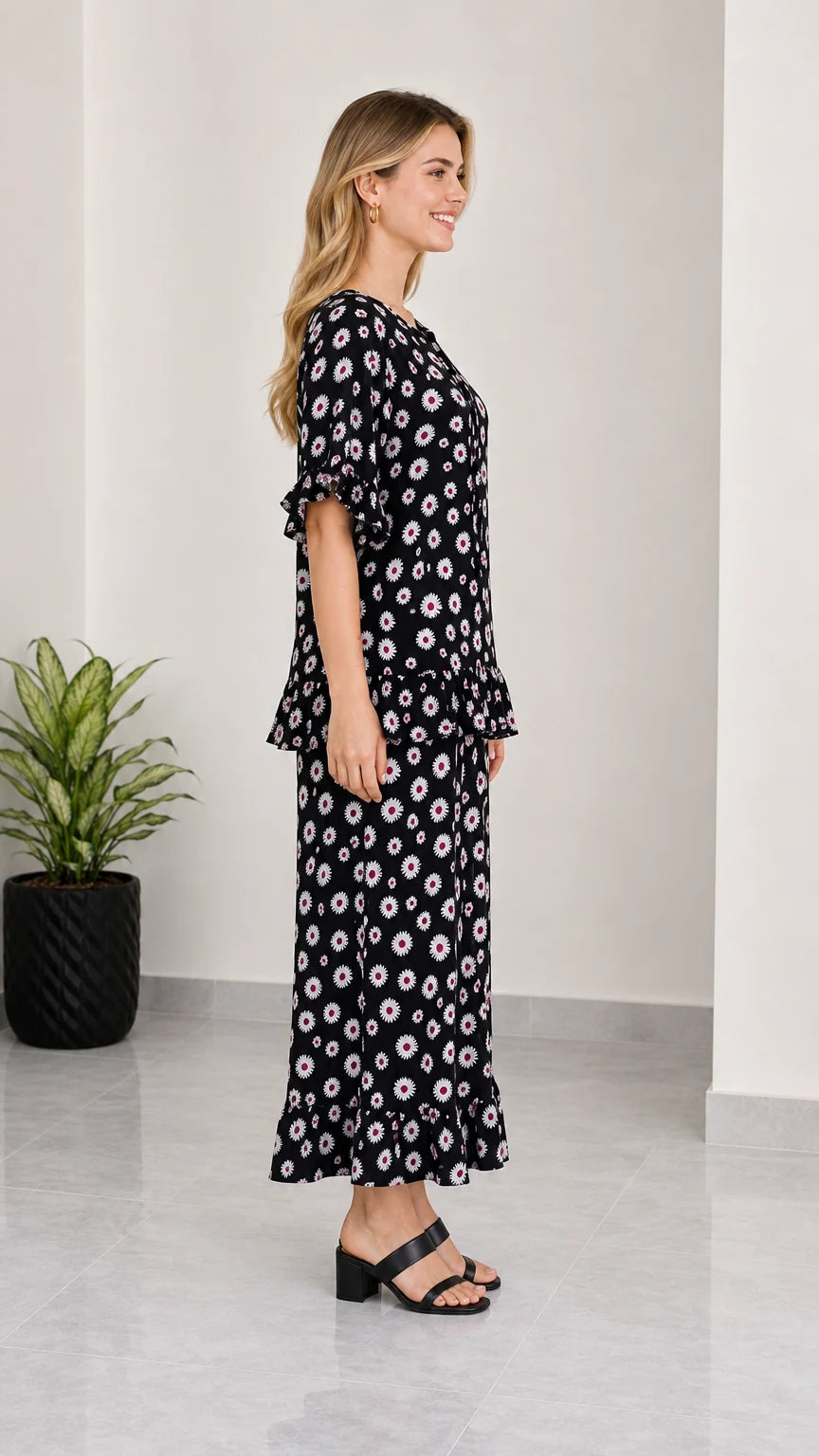 Side profile view of women's black floral matching top and maxi skirt set