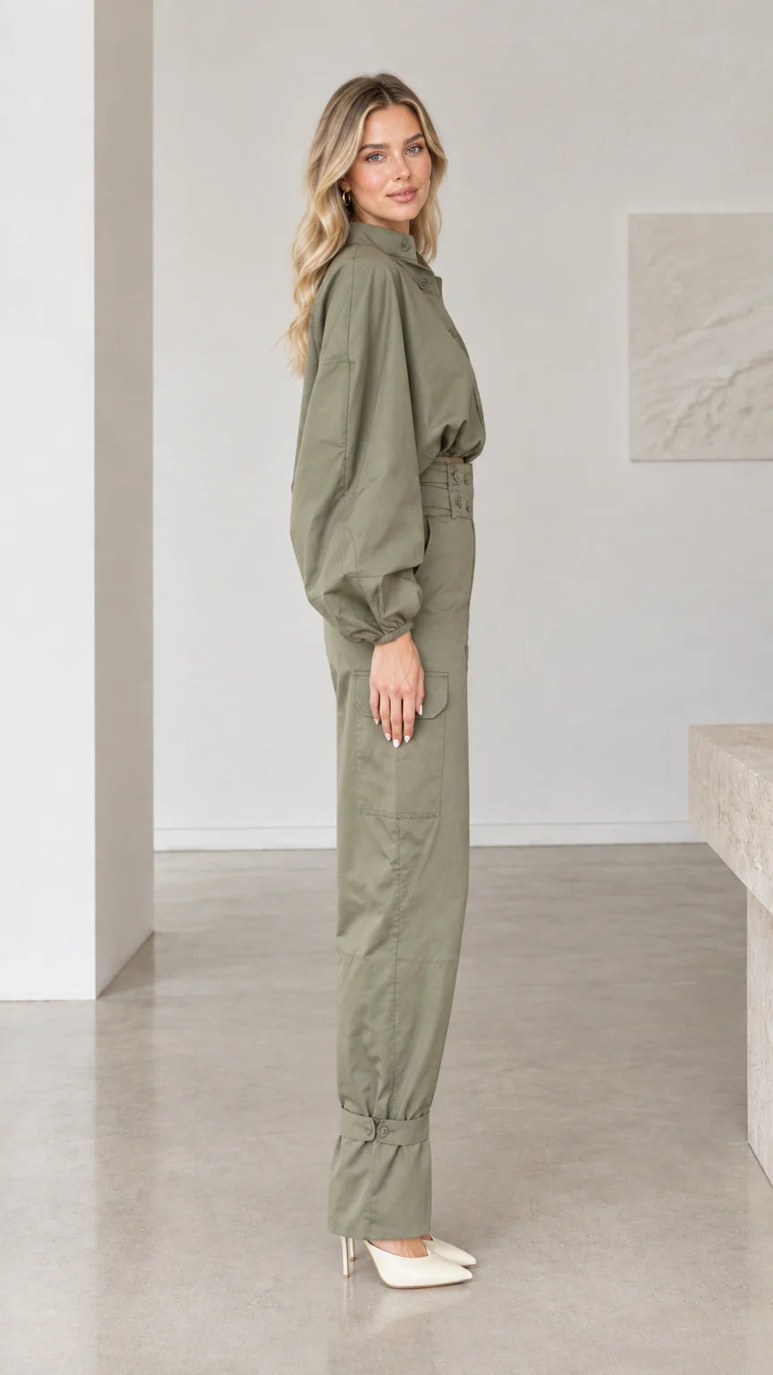 Side profile view of woman modeling olive green long sleeve utility jumpsuit