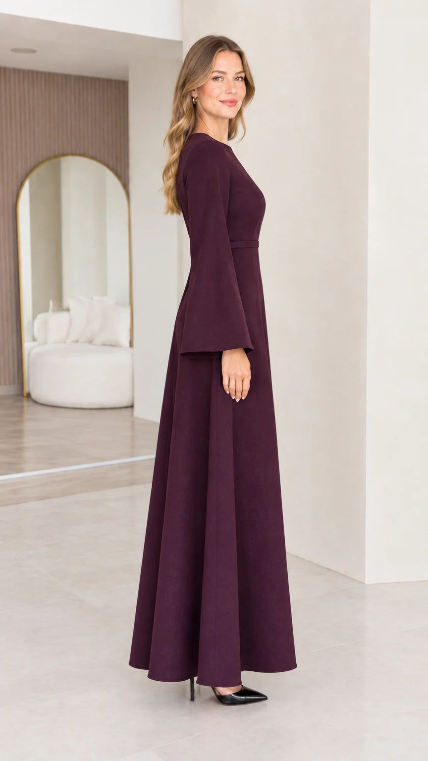 Side view of the burgundy long sleeve maxi dress showing its flowing A-line skirt