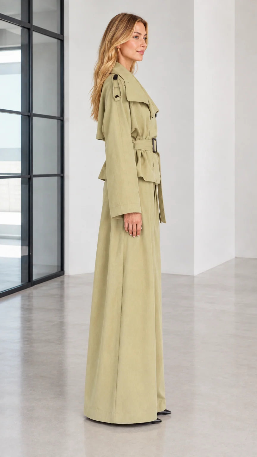 Side profile of woman in sage green two-piece trench jacket and wide trousers