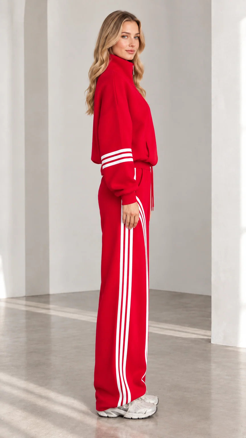 Side profile view of red two-piece tracksuit showing contrast leg stripes