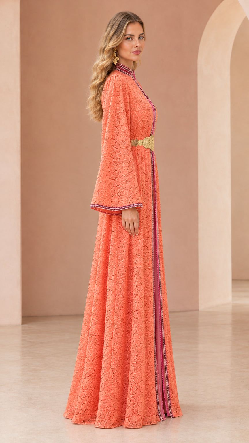 Side profile view of woman wearing flowing coral lace kaftan dress
