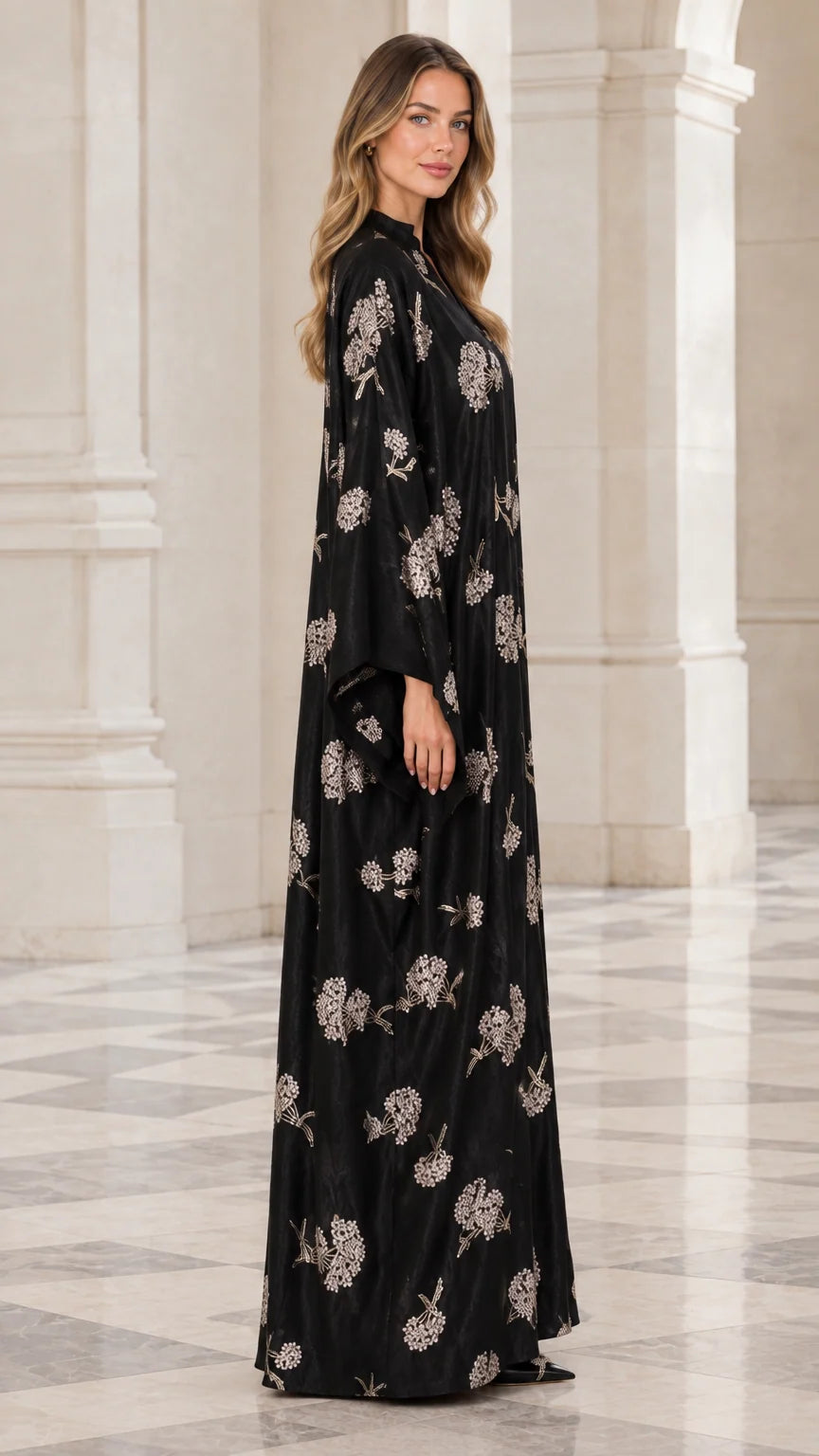 Side angle of woman wearing full length black floral embroidered abaya dress