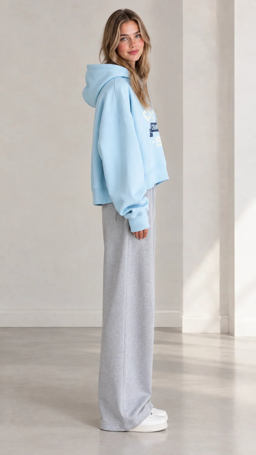 Side profile view of woman wearing Light Blue cropped fleece hoodie