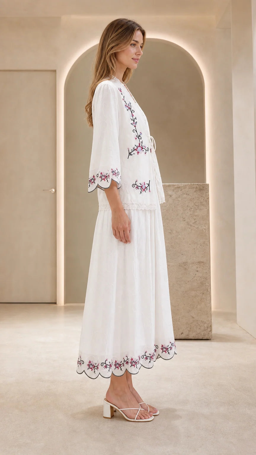 Side profile view of model in white embroidered dress set