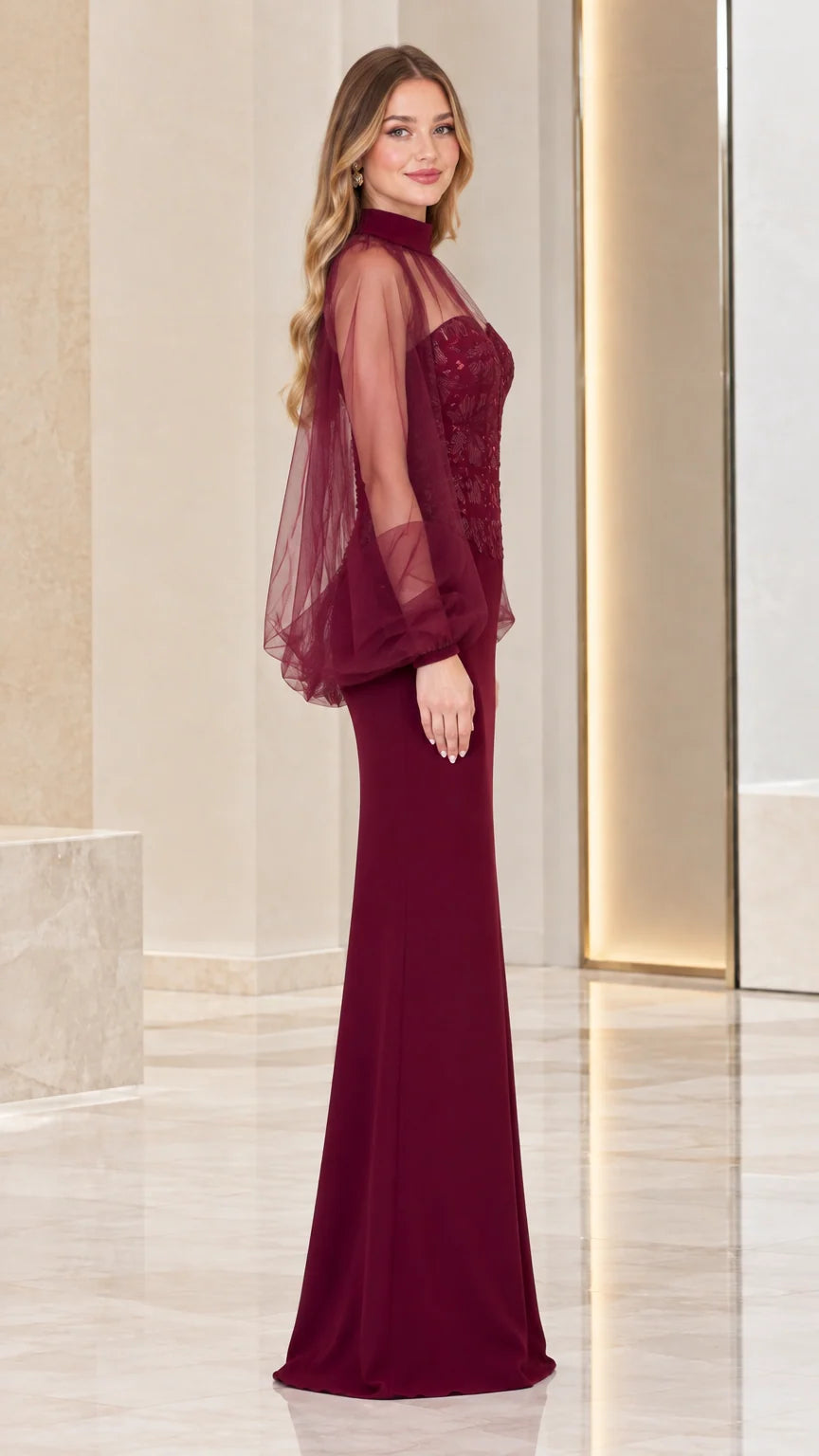 Side view of woman wearing burgundy formal maxi gown with sheer tulle sleeves
