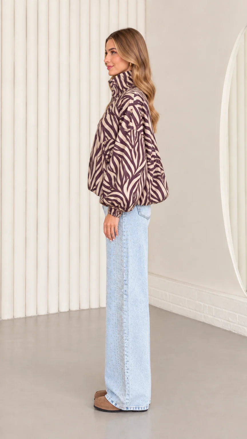 Side profile view of mocha brown zebra print blouson jacket showing sleeve volume and high stand collar