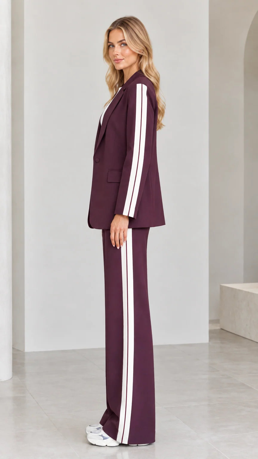 Side view of model in burgundy striped blazer suit set showing sleeve and pant stripe detailing