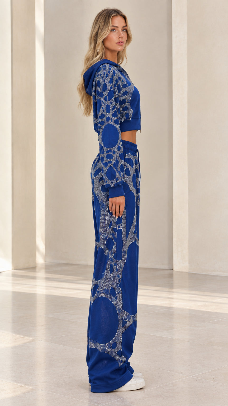 Side profile of woman modeling Royal Blue rhinestone tracksuit set