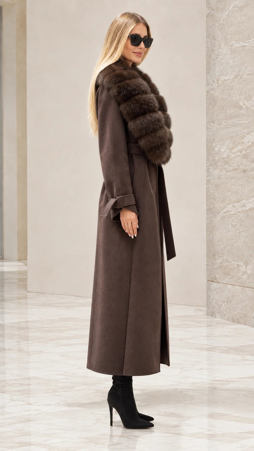 Side profile of woman wearing brown belted maxi coat with faux fur trim