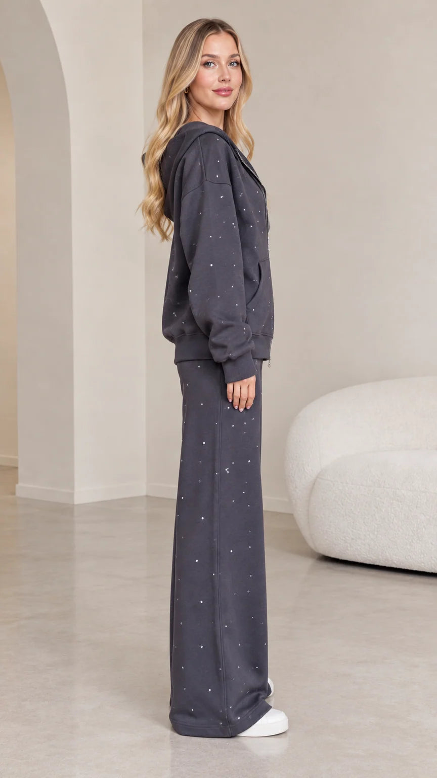 Side profile view of dark grey rhinestone two-piece tracksuit set on model