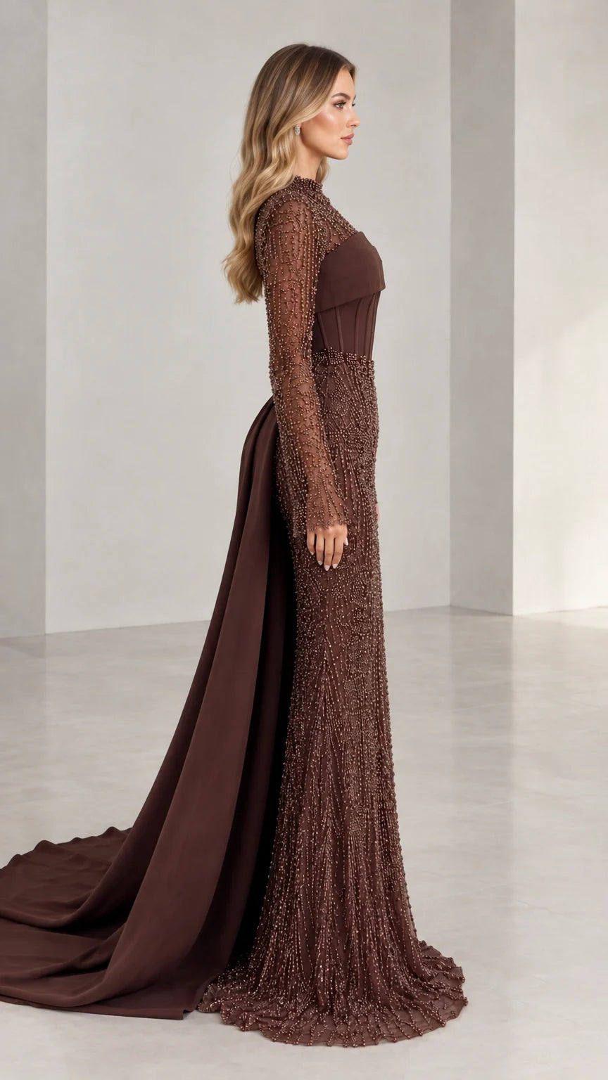 Side profile view of woman modeling brown beaded long sleeve formal gown with sweeping train