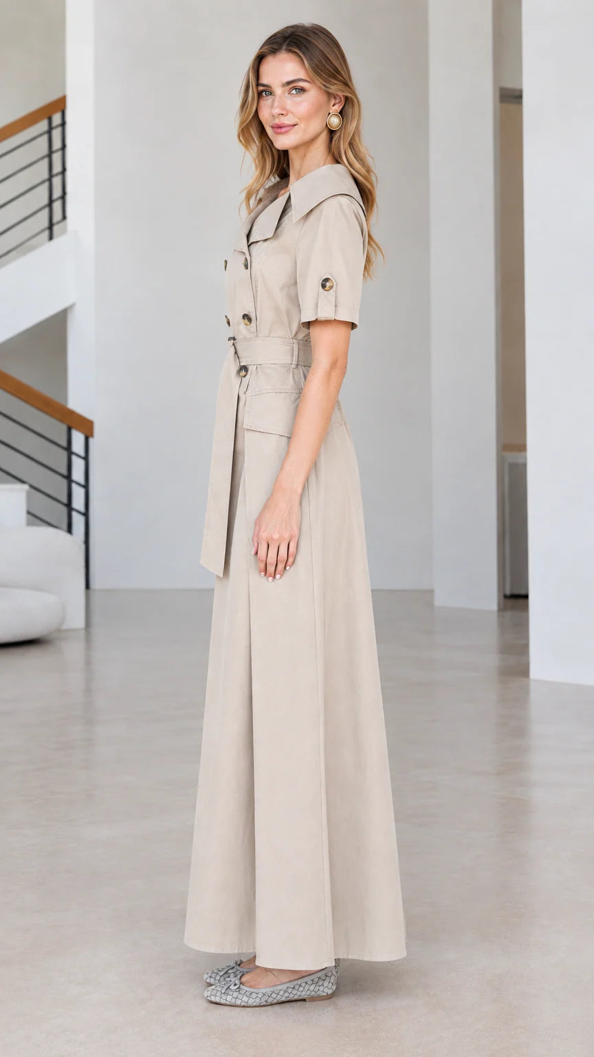 Side view of beige tailored trench maxi dress showing full-length skirt
