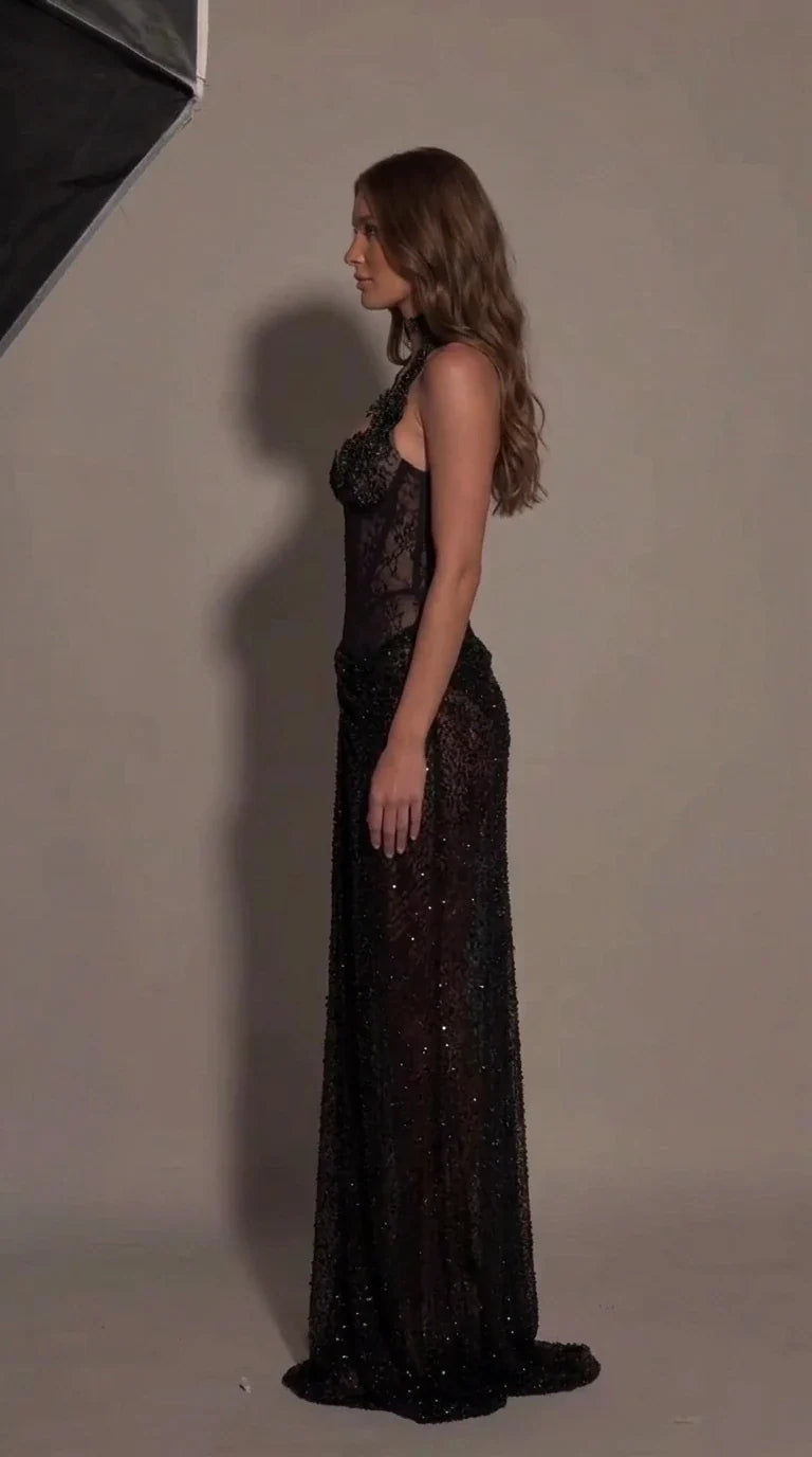 Side profile view of black sheer corset evening gown showing fitted silhouette