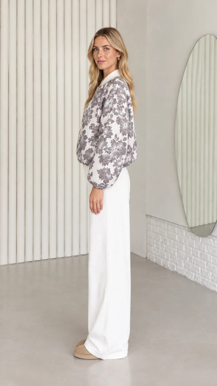 Side profile of model wearing floral bomber jacket with relaxed puff sleeves