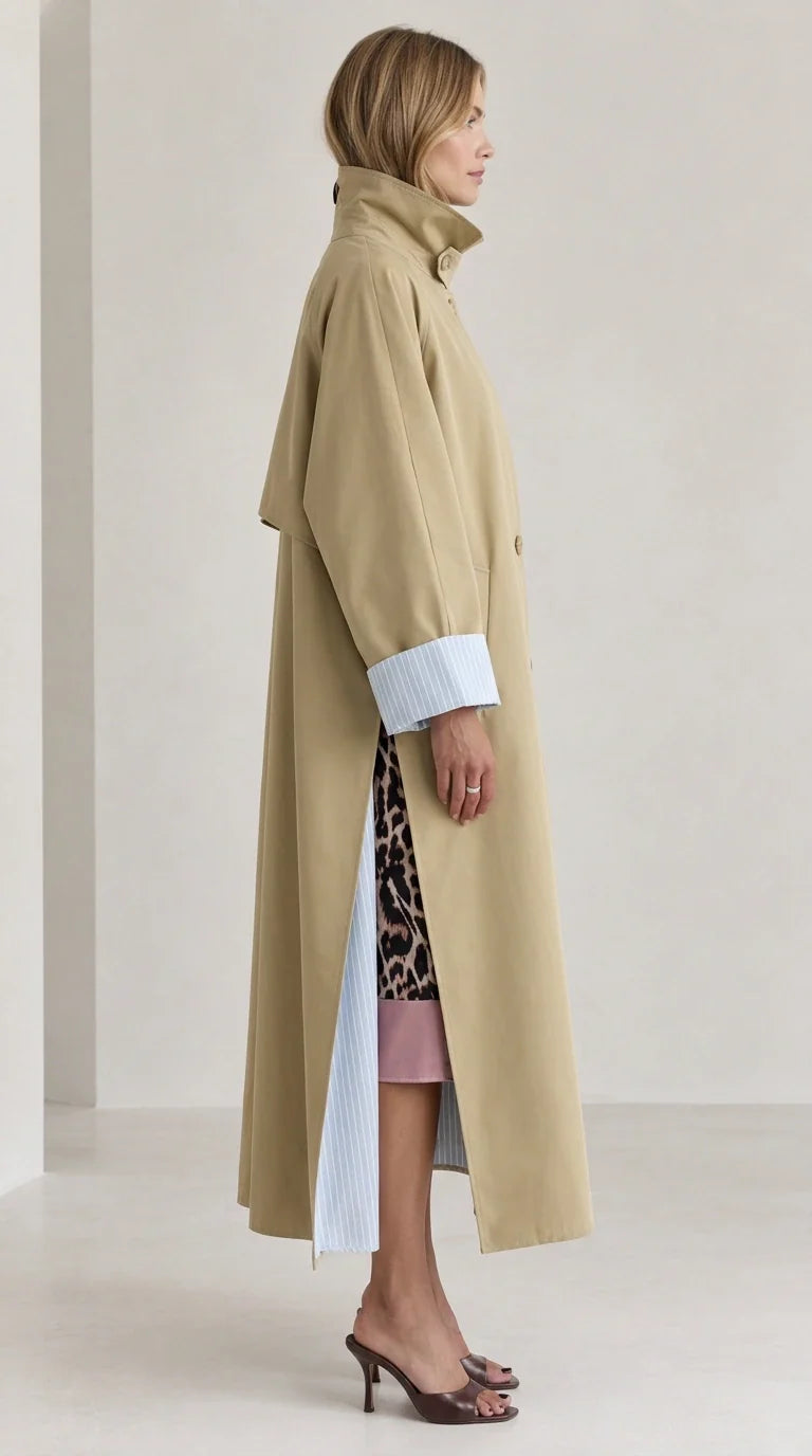 Side profile of woman in khaki maxi trench coat showing high collar and side slit