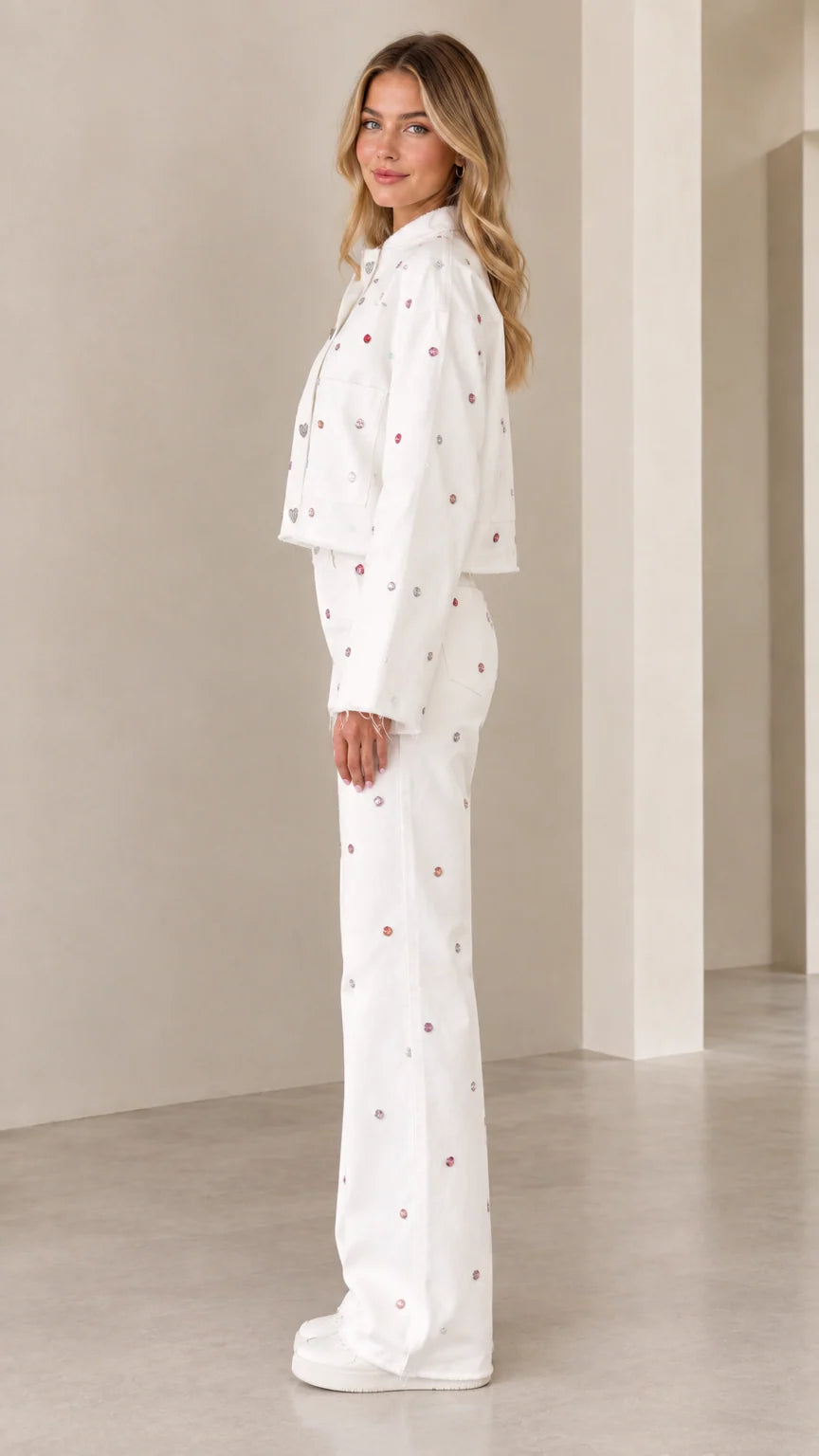 Side profile view of woman modeling white rhinestone two-piece co-ord pant set