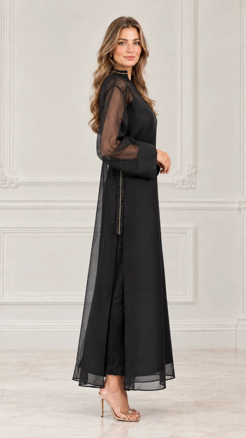 Side profile view of black sheer overlay maxi dress showing fluid drape