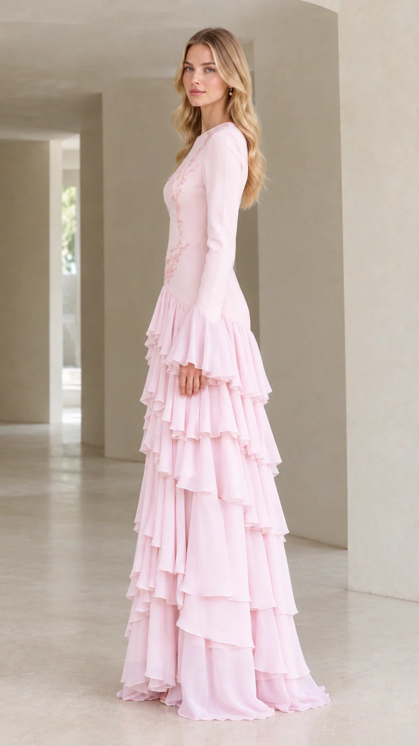 Side profile of woman wearing blush pink tiered ruffle long sleeve evening dress