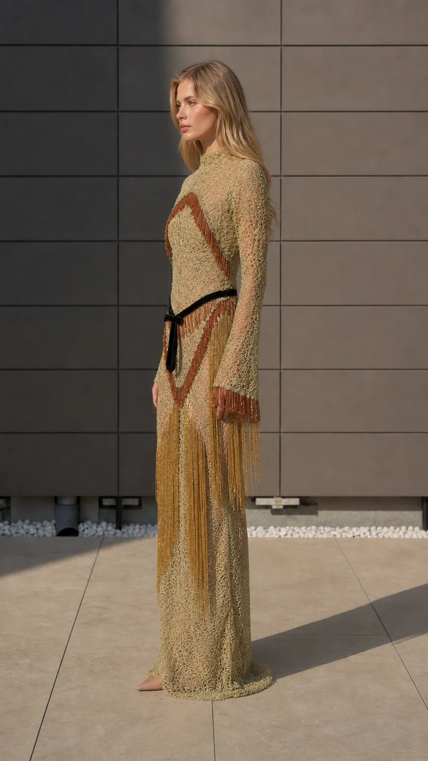 Side profile of model in gold fringe maxi dress