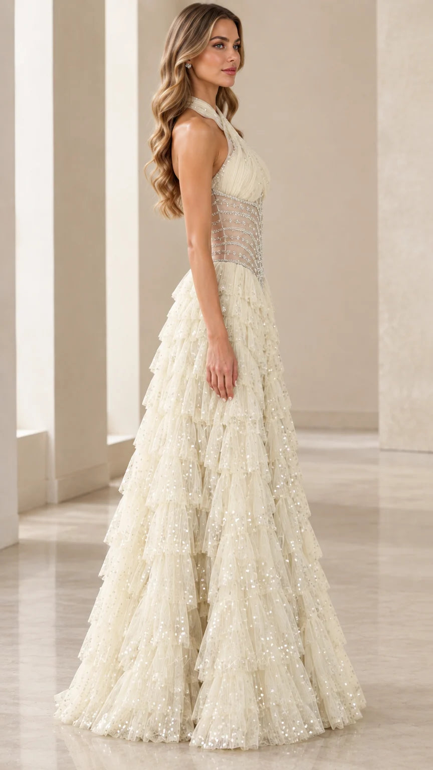 Model wearing an Ivory halter neck tiered tulle evening dress side profile view