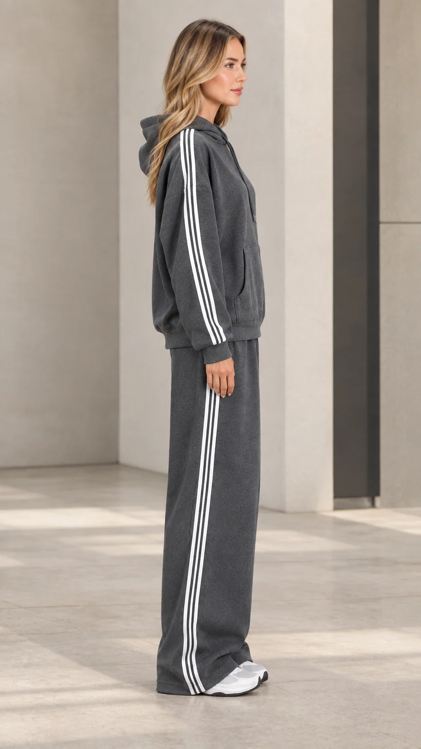 Side profile view of model wearing charcoal grey striped hoodie and sweatpants set
