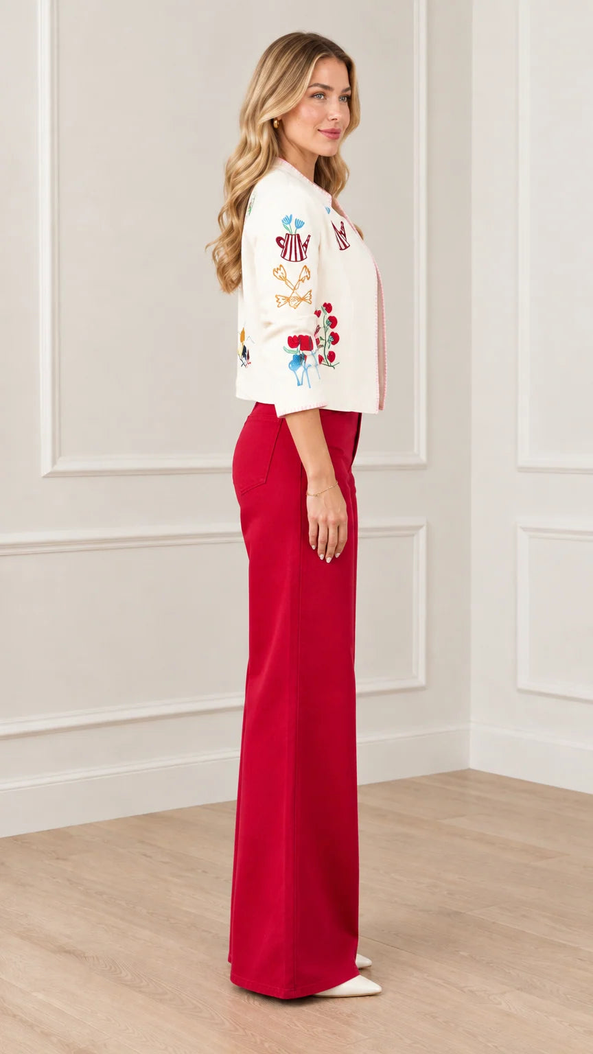Side profile view of cream whimsical embroidered cropped jacket
