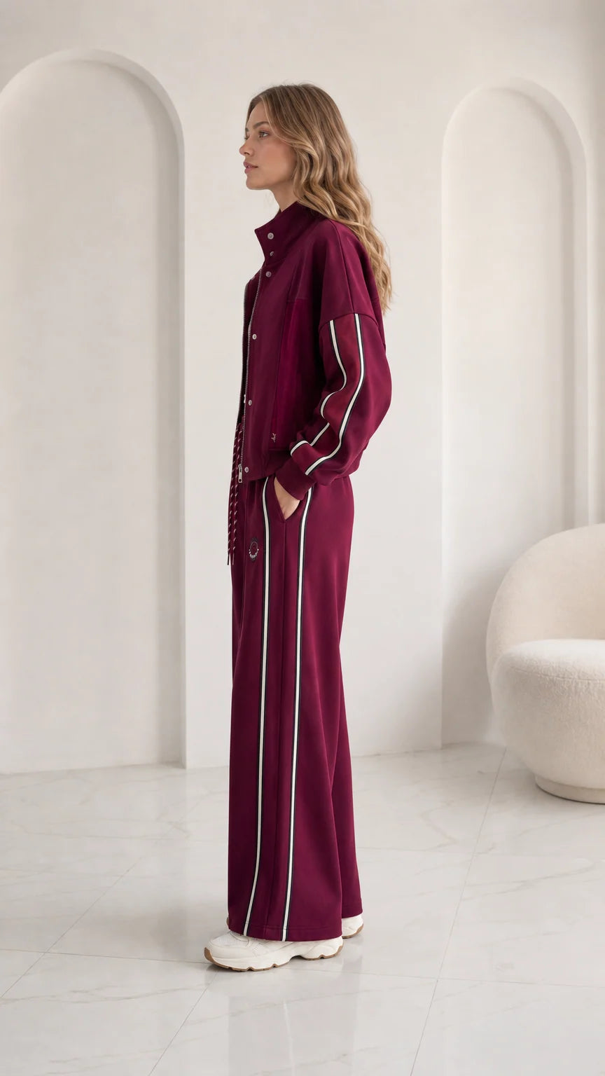 Side view of woman wearing burgundy sporty wide leg tracksuit set