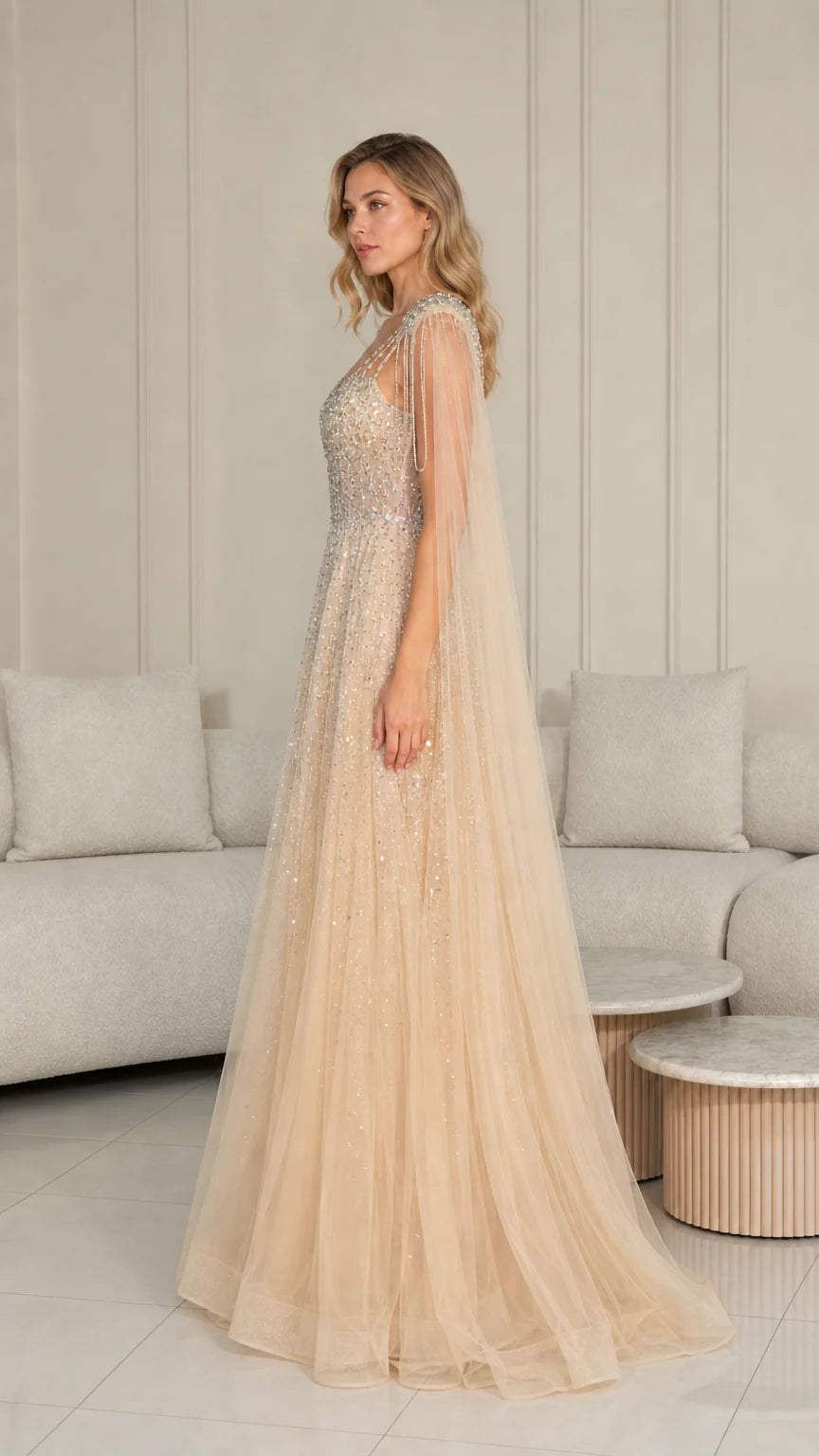 Side profile of champagne tulle formal dress with beaded shoulder cape