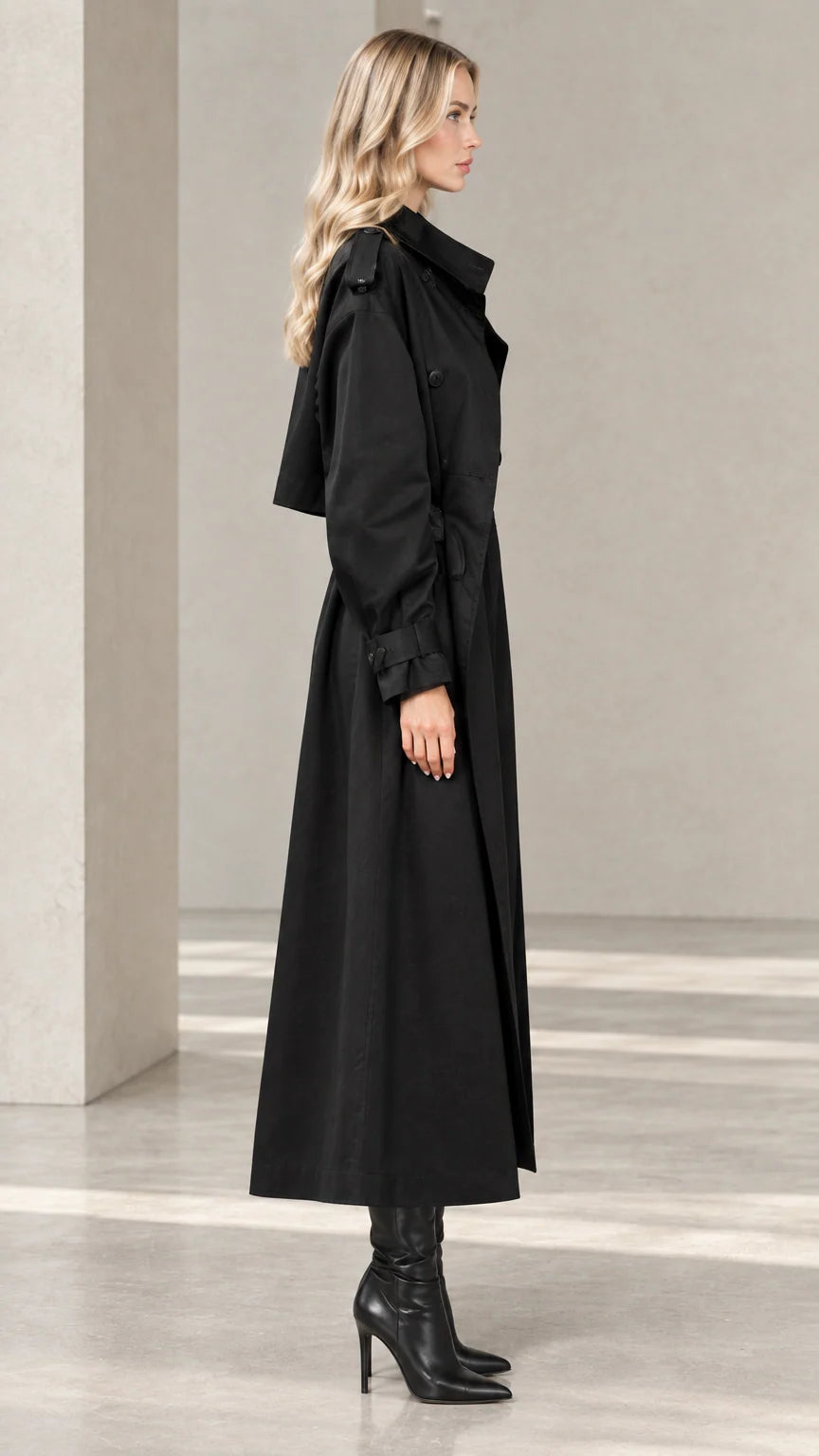 Side profile view of women's black maxi trench coat showing sleeve drape and length