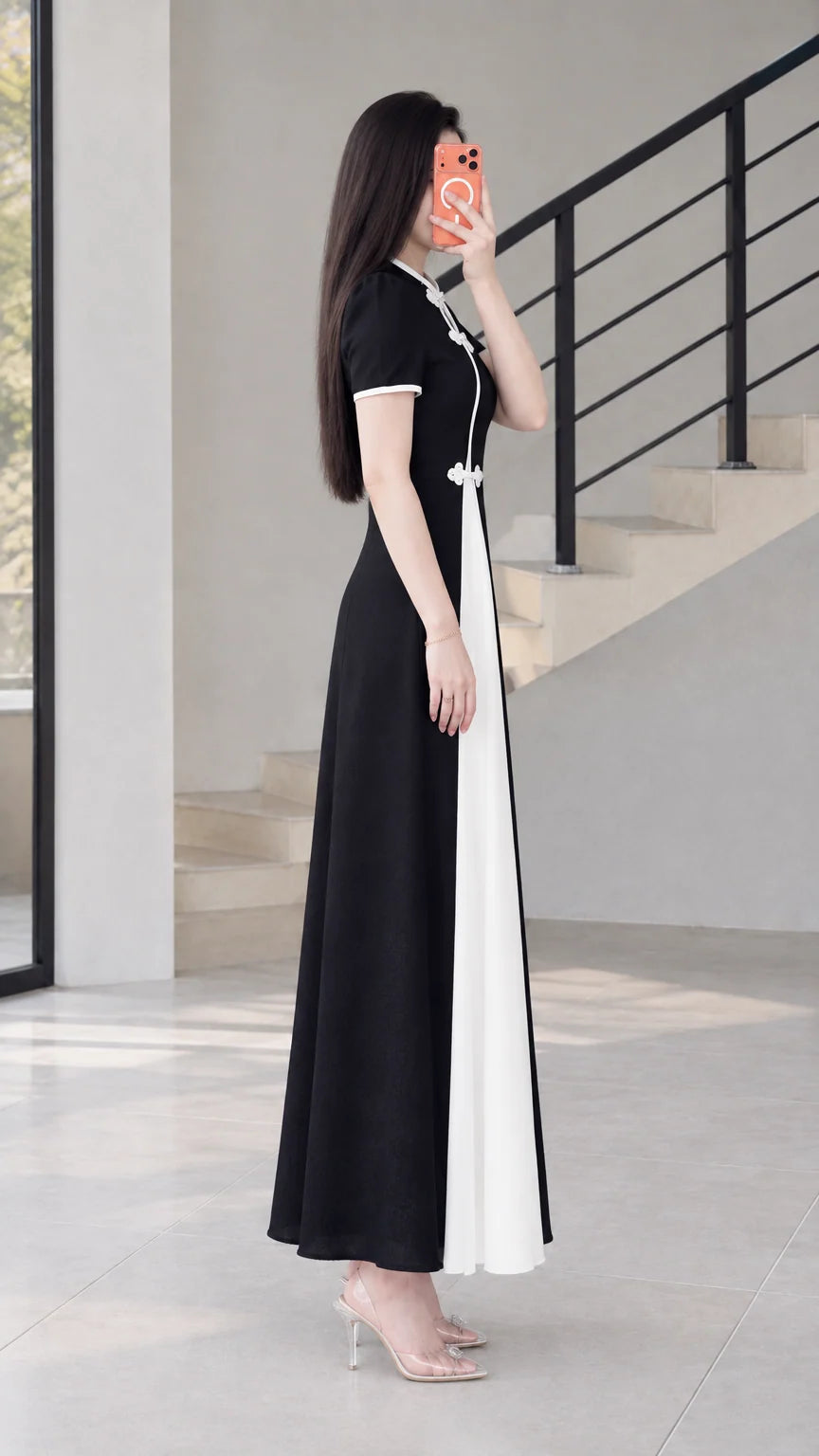 Side profile view of black contrast panel maxi dress with frog button accents