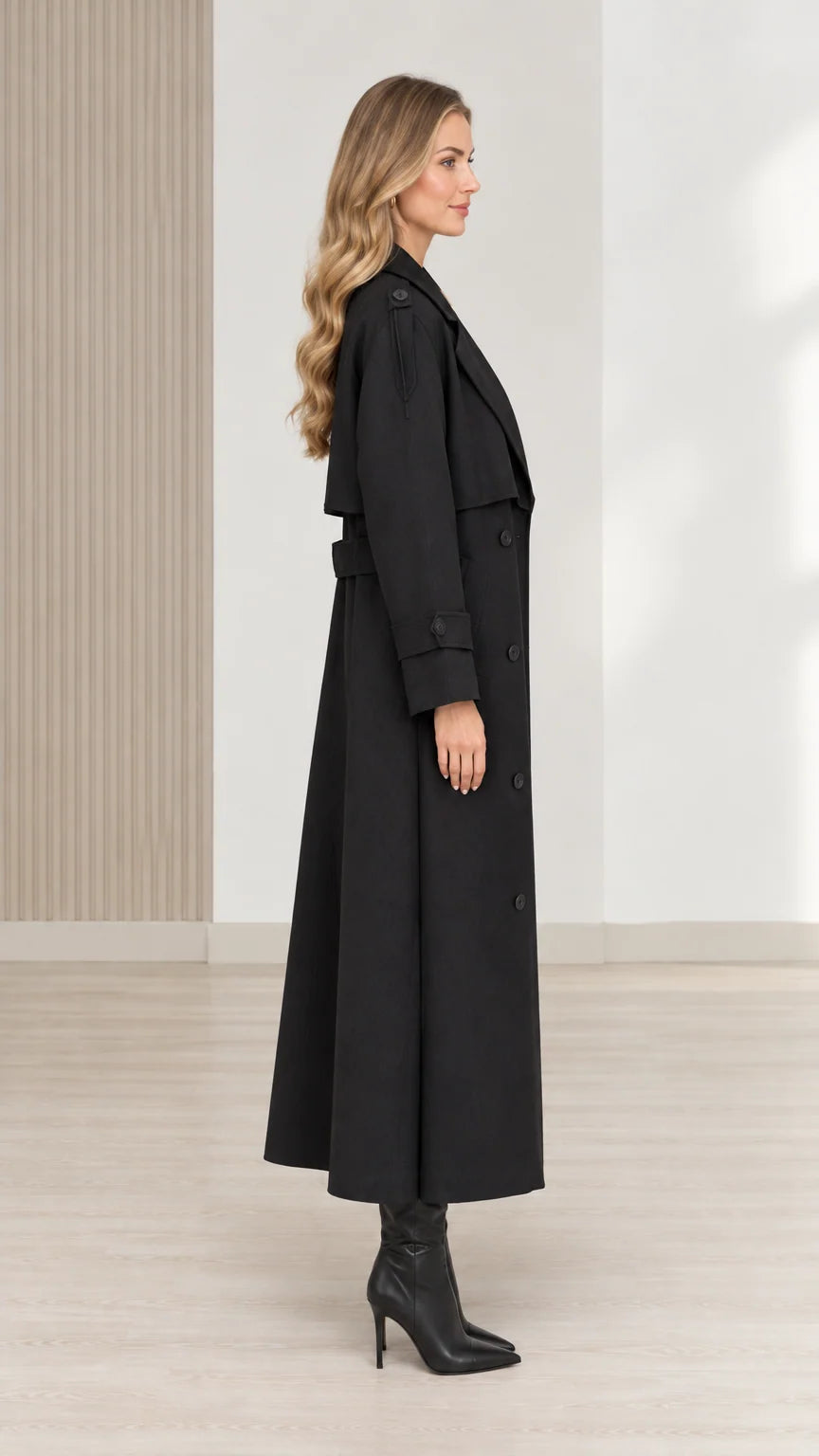 Side view of women's black long trench coat with belt