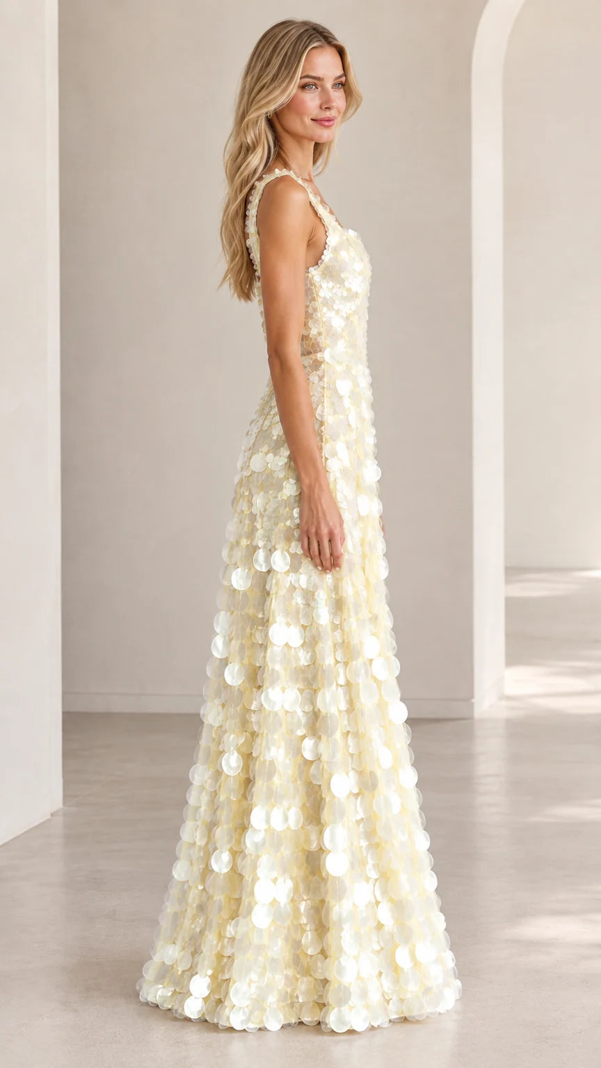 Side profile of model wearing ivory floor-length sequin evening dress