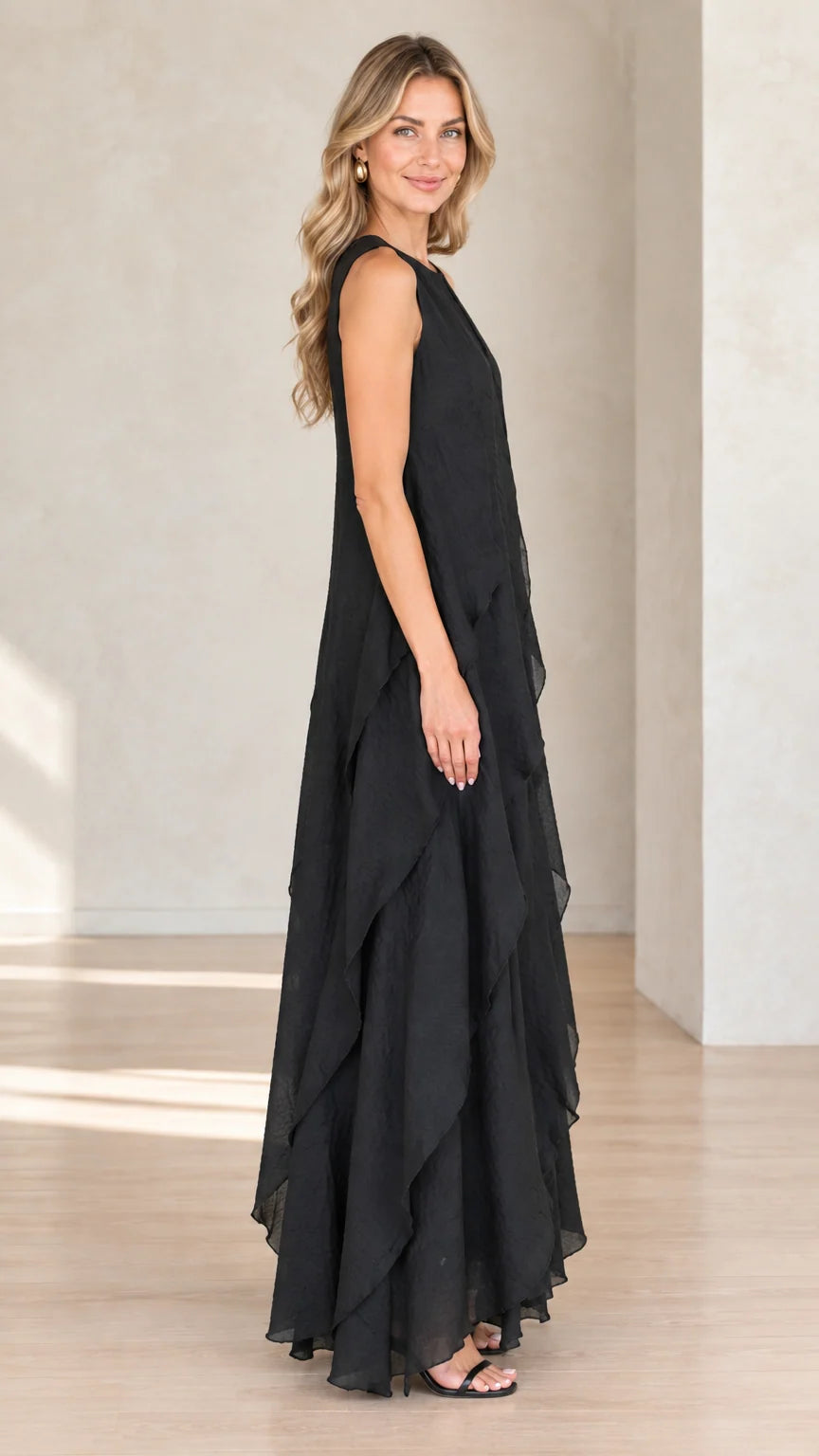 Side profile of model wearing black flowy tiered maxi dress