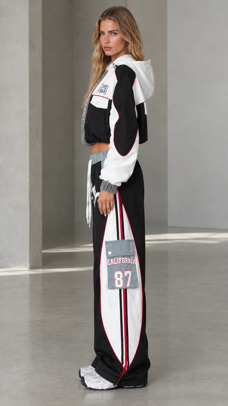 Side profile of model wearing black two-piece streetwear tracksuit set