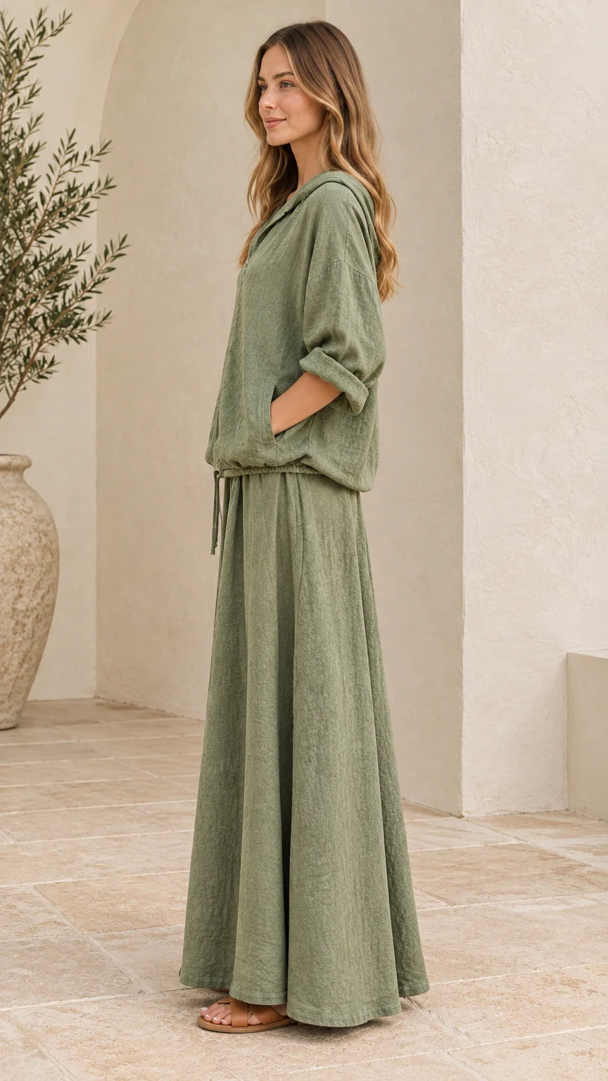Side angle view of woman in sage green two-piece maxi skirt and hoodie set
