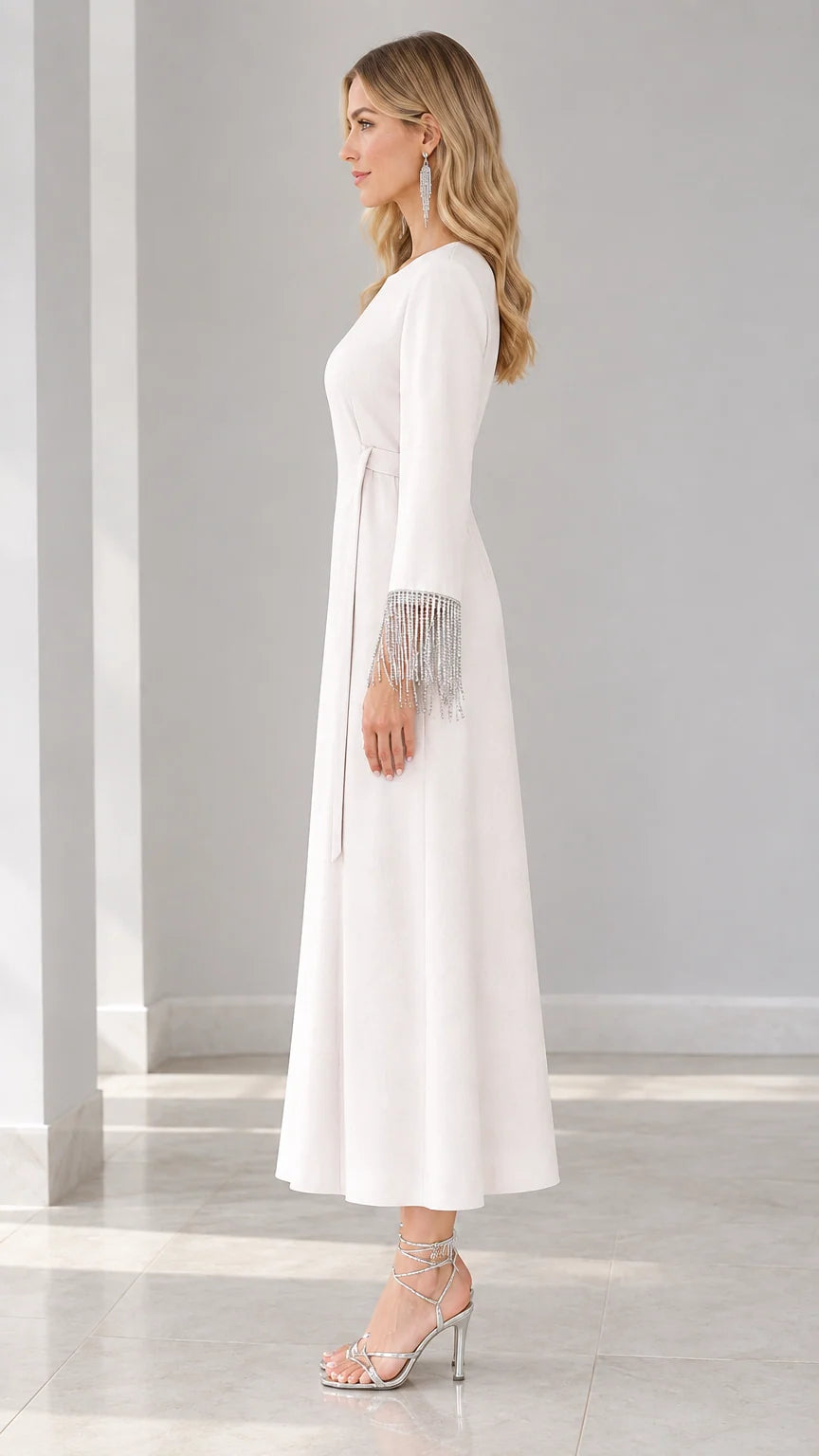 Side profile of white maxi dress with fringe sleeves and waist tie