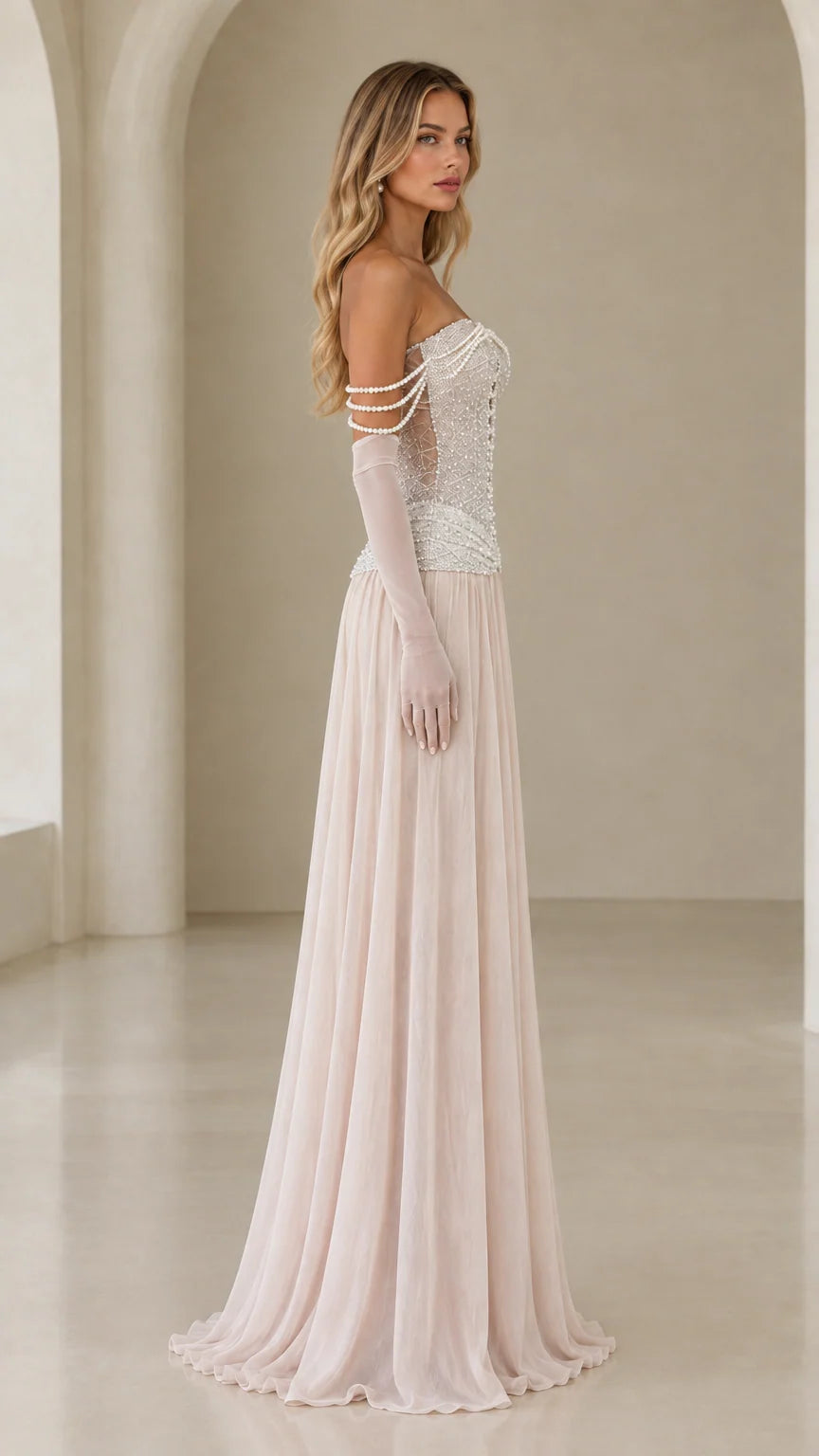 Side profile of model in champagne pearl embellished drop-waist maxi gown