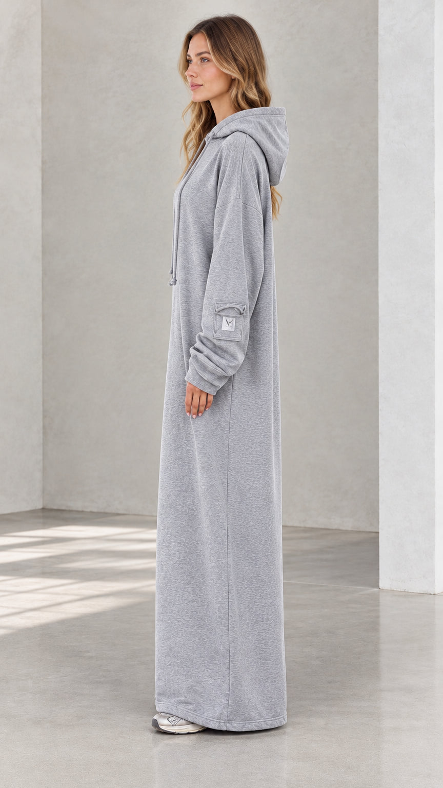 Side profile view of model in heather grey longline sweatshirt dress