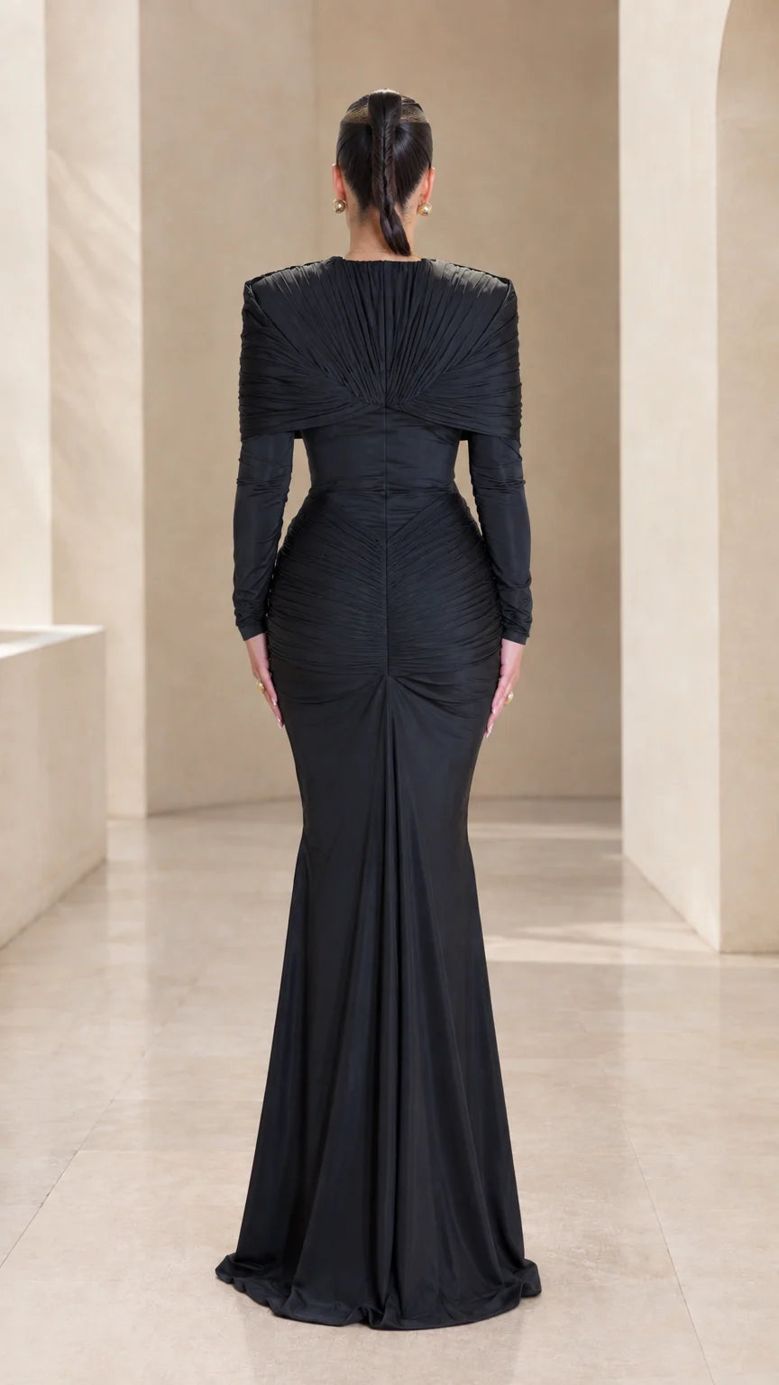 Back view of black structured cape shoulder long sleeve floor-length dress