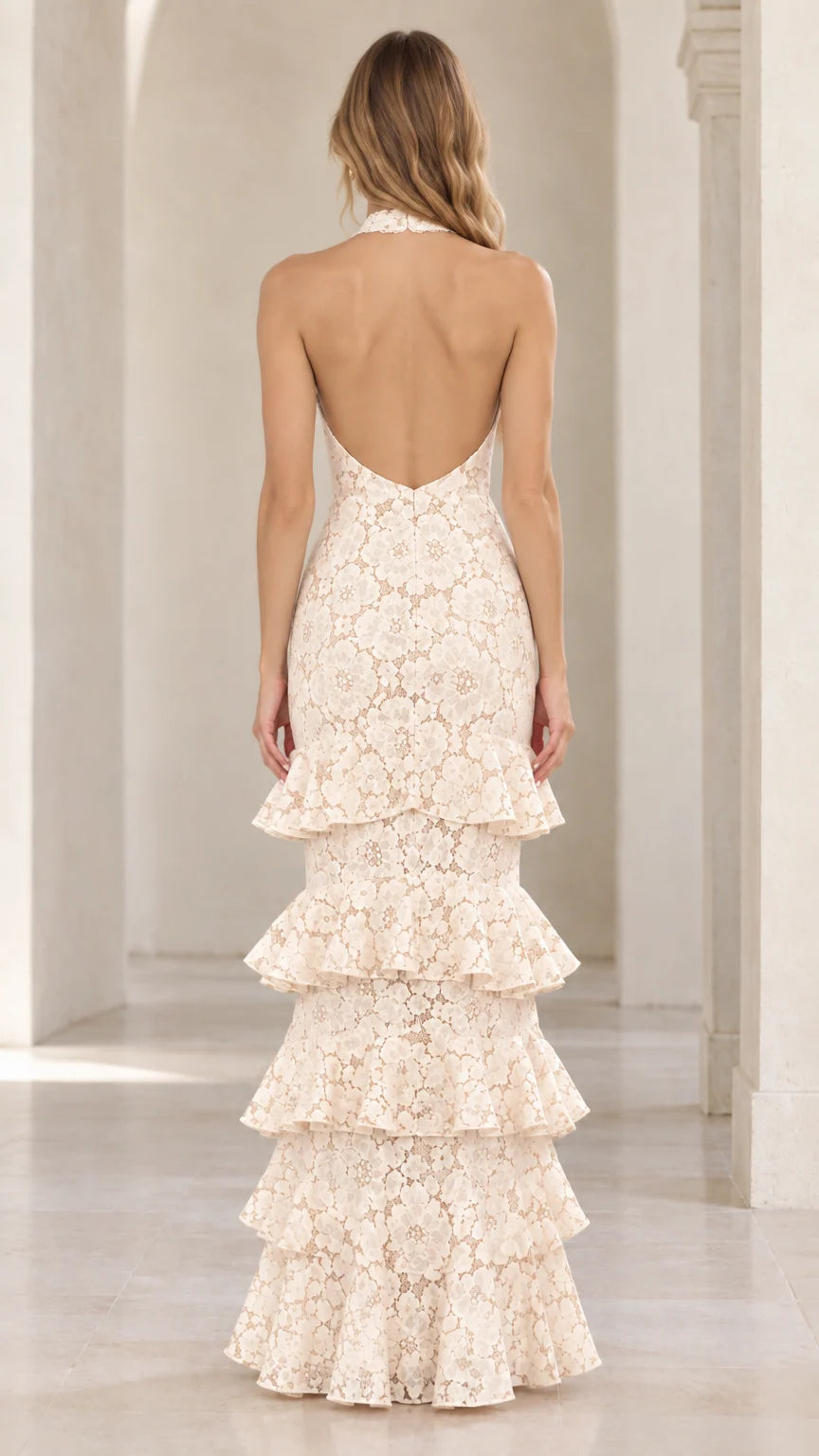 Back view of cream halter lace gown showing deep open back design and tiered skirt