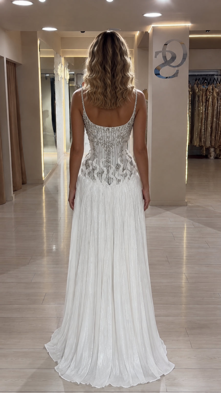 Back view of white crystal-beaded evening dress with open scoop back and pleated skirt