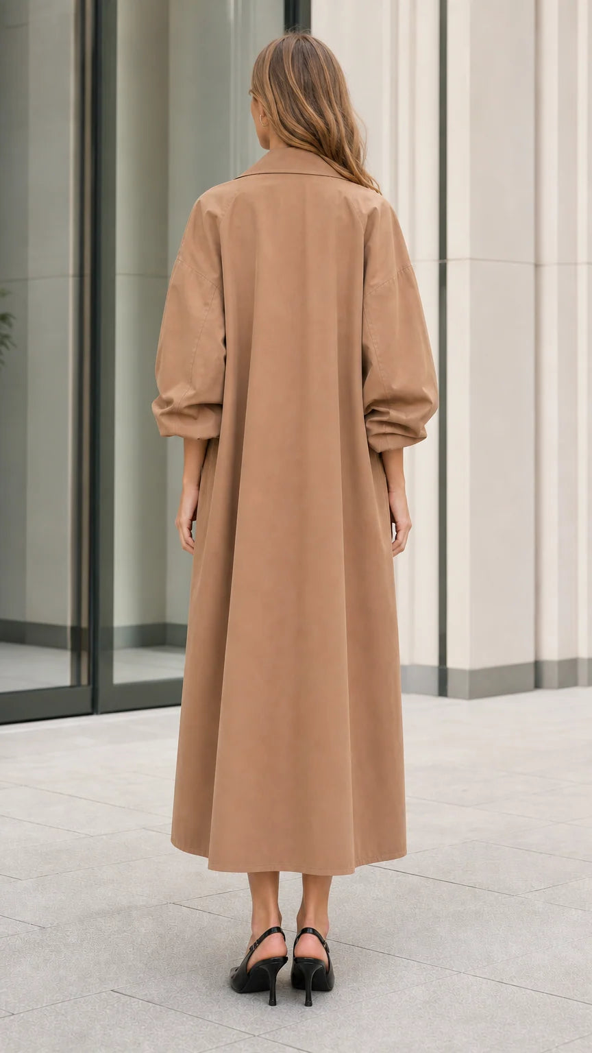 Back view of model showcasing the long sweeping silhouette of the camel trench coat